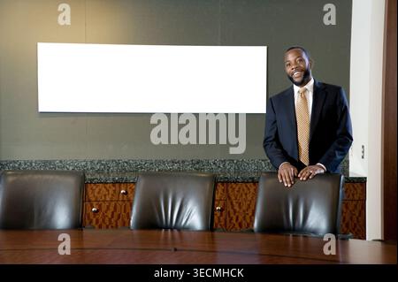 Black businessman in executive meeting conference room with blank monitor, Philadelphia, USA Stock Photo