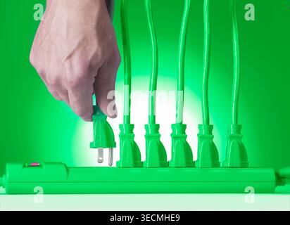 Hand plugging in multiple electrical cords in to power strip, USA Stock Photo