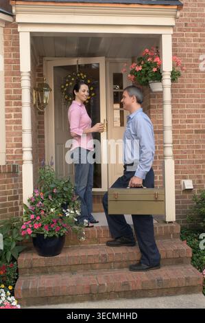 Repairman making HVAC maintenance service call to female homeowner, New Jersey, USA Stock Photo