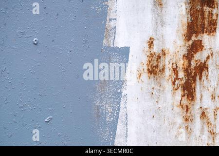 Roller painting the surface, gray paint on rusty metal garage Stock Photo