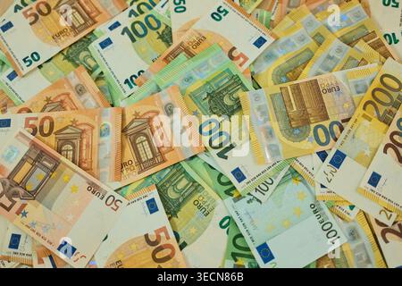 Euro banknotes are arranged in grouped stacks by denomination on a wooden surface. Cash savings and wealth concept for finance, budgeting, investment Stock Photo