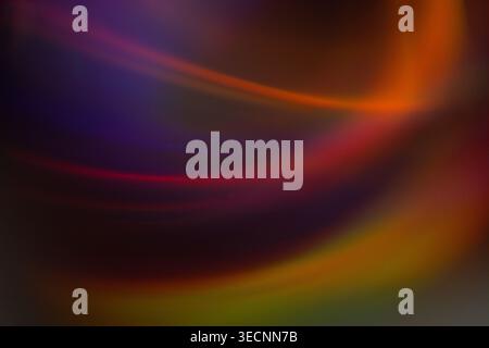 Abstract image featuring colorful light trails in shades of orange, purple, and red, creating a flowing pattern on a dark background Stock Photo