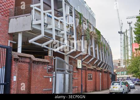 Exterior view of a historic sports stadium, likely a cricket ground, in London, UK. The foreground features a traditional red brick perimeter wall Stock Photo