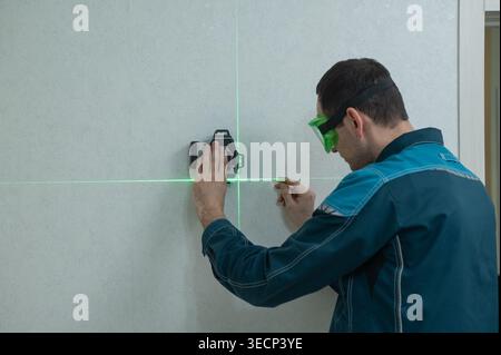 A man measures distance with a laser level.  Stock Photo