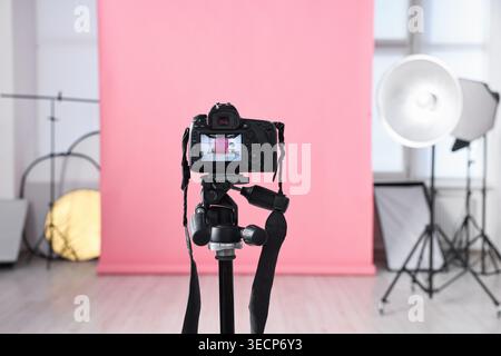 Different lighting equipment and modern camera on tripod in photo studio, selective focus Stock Photo