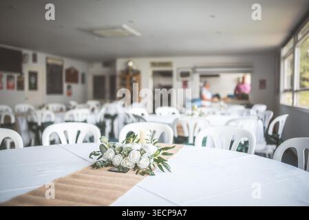 A beautiful wedding reception is set up with tables, chairs, and floral arrangements, ready for guests to arrive Stock Photo