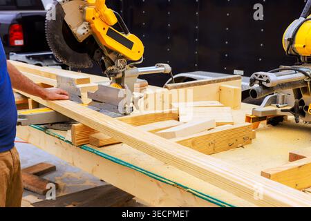 Works on woodworking project using saw various wood pieces on table in workshop. Stock Photo