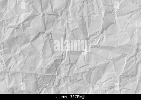 Crumpled white paper showing wrinkled texture, creases and folds, creating an abstract background or surface for copy space Stock Photo