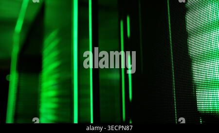 Close up of green LED pixel screen and glowing vertical light lines. Dark, futuristic technology concept background with digital matrix feel. Abstract Stock Photo