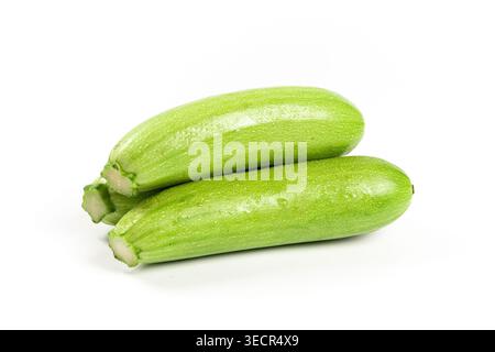 Fresh green zucchini vegetables showing water drops on a white background Stock Photo