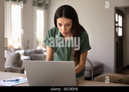 Woman working online using laptop at home office Stock Photo
