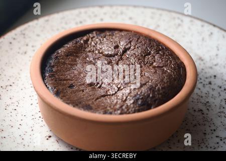 Chocolate dessert in a clay dish served on a table Stock Photo