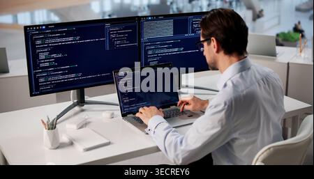 Man Focused On Coding Laptop, Developing Web Project In Modern Office. Stock Photo