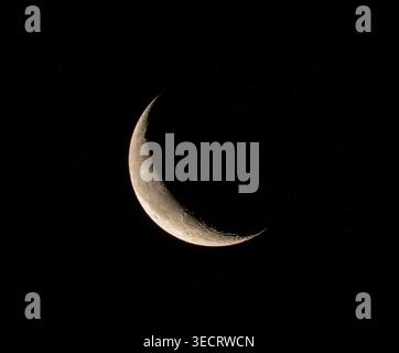 A captivating image of a crescent moon shining brightly against the pitch-black night sky, showcasing its delicate curves and ethereal glow in a seren Stock Photo