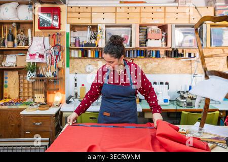 Woman artisan measuring fabric for upholstery process Stock Photo