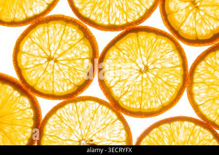 Vibrant close-up of overlapping orange slices forming a bright citrus background. Juicy translucent segments and peel edges create a fresh, sunny text Stock Photo