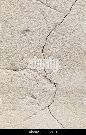 Close-up of cracked concrete pavement with a thin fissure running through a rough gray surface, creating an urban texture background for construction, Stock Photo