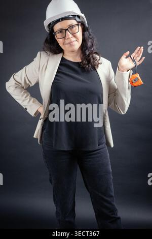 Female engineer in hard hat holding measuring tape Stock Photo
