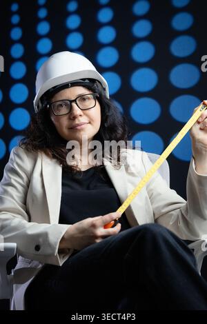 Woman engineer holding measuring tape developing project Stock Photo