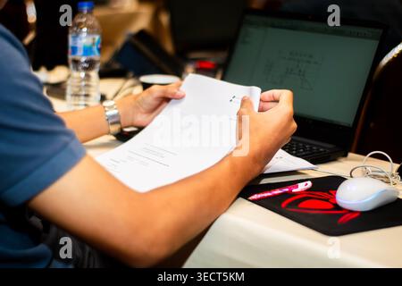An engineer reviewing design blueprints with ETABS structural engineering software open on a laptop screen at a computer-aided training lab in Bangkok Stock Photo