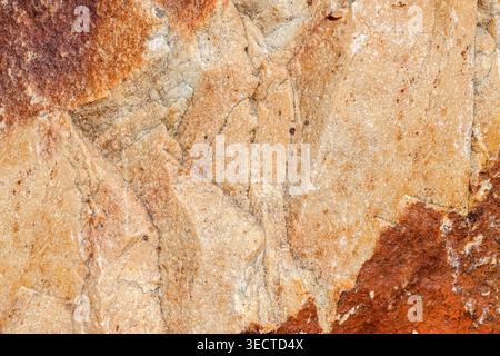 Brown beige stone rough texture with red stripes in corners macro Stock Photo