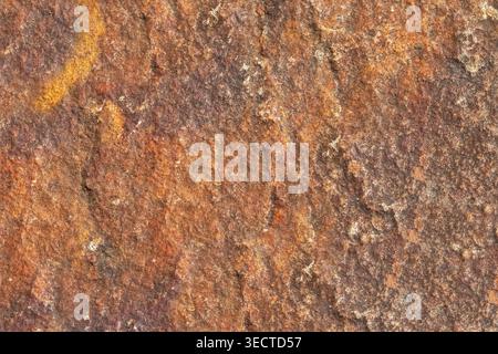 Brown stone rough texture surface with orange inclusions macro Stock Photo