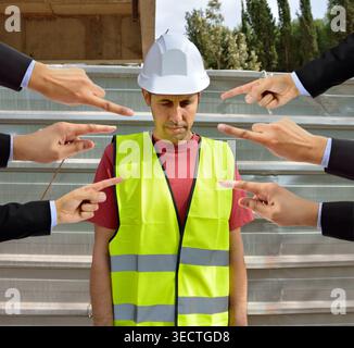 many hands pointing the bullying a workman that is suffering  mobbing on concept of accusation guilty shy,and in concept of dismissal from work Stock Photo