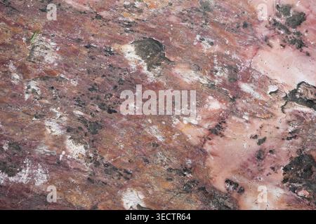 High-resolution overhead shot of raw pink marble featuring aged patina and dark mineral veins Stock Photo