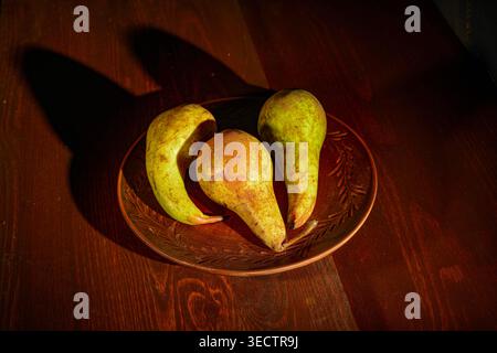Still life with pears arranged in a ceramic plate Stock Photo