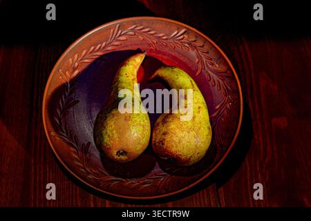 Still life with pears arranged in a ceramic plate Stock Photo