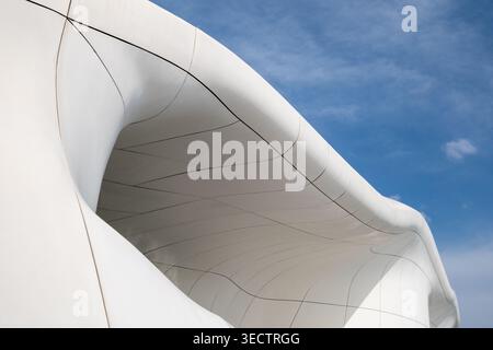 Abstract white curved architecture with smooth geometric patterns and blue sky Stock Photo