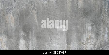 Close up of a weathered concrete wall surface with cracks, scratches, gouges, and white deposits visible across the rough textured horizontal surface Stock Photo