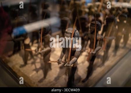 GRAND EGYPTIAN MUSEUM, CAIRO, EGYPT - 25 MAY 2025: A close-up view of ancient Egyptian wooden soldier figurines carrying spears and bows, displayed be Stock Photo