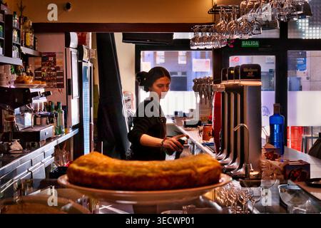 Waitress pouring milk into a coffee cup at a local Spanish bar. Stock Photo