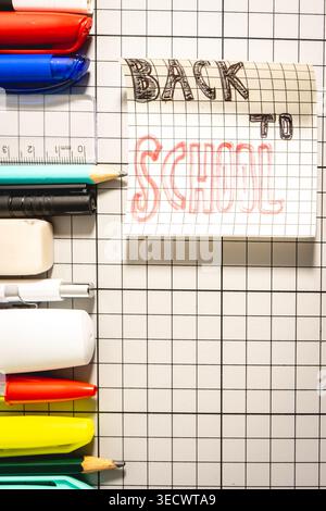 A Note with Back to School on it with different school Supplies, on a White background. Back To School background. Stock Photo