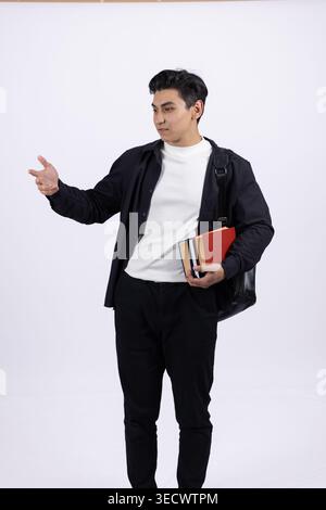 Young man in elegant suit holding a small red heart box and pointing Stock Photo
