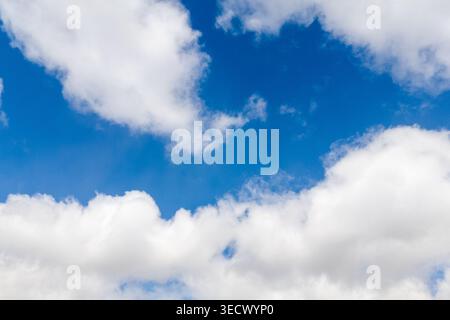 Low angle view of white clouds scattered across a blue sky Stock Photo