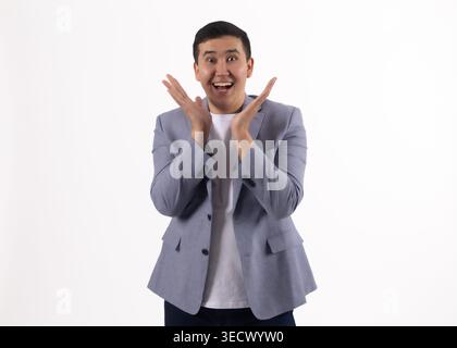 Young man in a blue jacket clapping his hands and smiling Stock Photo