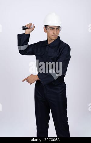 Young man in builder uniform pointing finger aside in studio Stock Photo