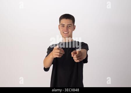 Young man in black t-shirt pointing finger at camera Stock Photo