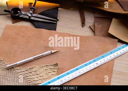 Leather Craft Workshop Flat Lay with Tools Ruler Pencil and Various Leather Pieces on Wooden Table Stock Photo