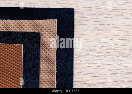 Collection of Black Tan and Brown Leather Texture Samples on Wooden Background Stock Photo