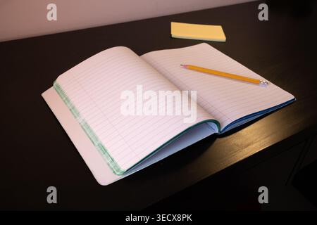 Opened notebook with a pencil on a dark wooden desk Stock Photo