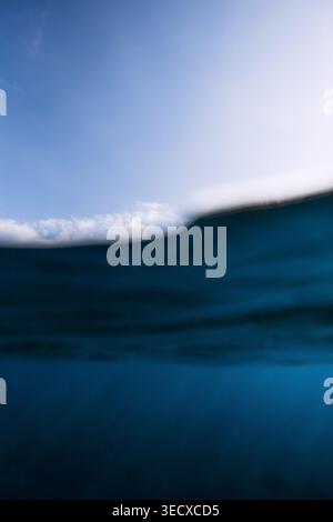 Split shot of ocean wave and sky, minimal seascape with blue water and clouds, marine background Stock Photo
