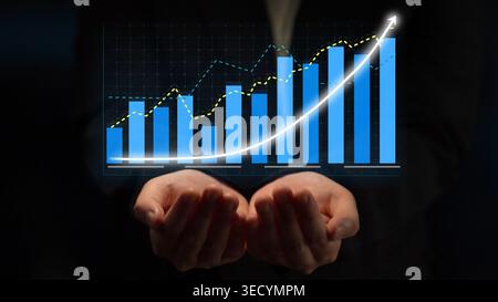 A conceptual image showcasing hands supporting a digital graph with rising bars and a trend line, symbolizing growth, success, and business Stock Photo