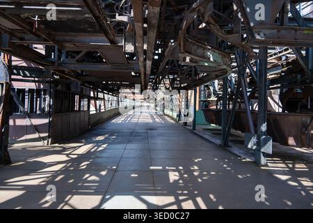 Long perspective view of an industrial corridor with steel beams and shadows at Völklingen Ironworks in Saarland, Germany. Stock Photo
