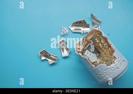 Broken jar with metal pieces on blue background Stock Photo