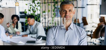 Veteran consultant providing insights to collaborative team with assurance Stock Photo