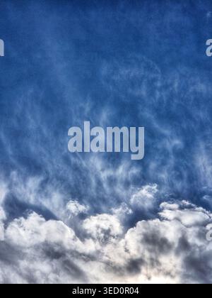 Dramatic evening sky with heavy cumulus clouds in deep blue and grey tones. Stock Photo