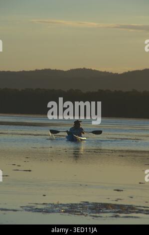 Man kayaking on a Tuggerah Lake at sunset on the Central Coast of New South Wales, Australia Stock Photo